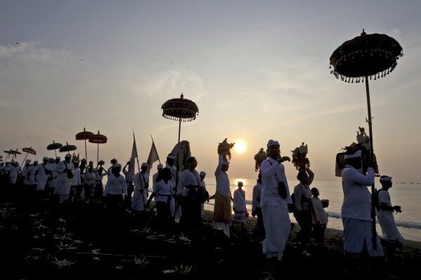 Balinese Hindus participate in a purification ceremony during sunrise on Melasti at Padanggala beach in Bali, Indonesia on Friday, March 8, 2024. Melasti is a day leading up to the New Year where Balinese Hindus perform rituals as an act of symbolic cleansing. (AP Photo/Firdia Lisnawati)