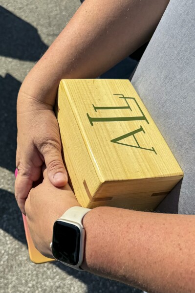 Shannon Doughty holds a wooden box on Aug. 29, 2024, in Westfield, Indiana, that had contained some of the cremated remains of her late brother, Allen Livingston, who was identified in October 2023 as the ninth known victim of suspected serial killer Herbert Baumeister. (AP Photo/Rick Callahan)