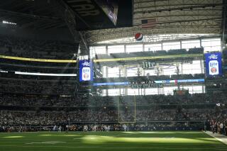 Fans at AT&T Stadium watch during the first half of an NFL wild-card playoff football game between the Dallas Cowboys and the San Francisco 49ers in Arlington, Texas, Sunday, Jan. 16, 2022. (AP Photo/Tony Gutierrez)