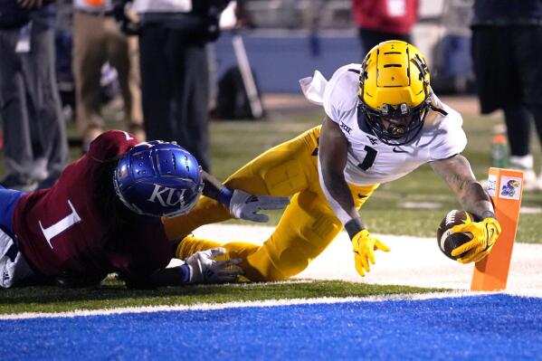 West Virginia wide receiver Winston Wright Jr. (1) dives into the end zone for a touchdown against Kansas safety Kenny Logan Jr. (1) during the second quarter of an NCAA college football game Saturday, Nov. 27, 2021, in Lawrence, Kan. (AP Photo/Ed Zurga)