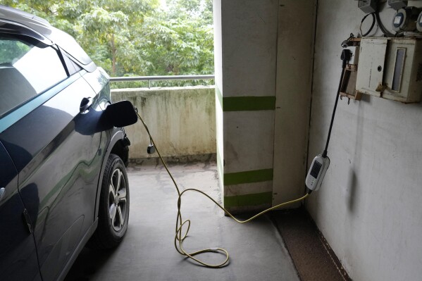 A car gets charged at an electric vehicle charging station at a residential building parking area in Mumbai, India, July 23, 2024. (AP Photo/Rajanish Kakade, File)