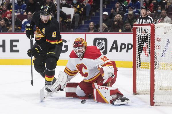 Vancouver Canucks' J.T. Miller (9) watches the rebound after Calgary Flames goalie Jacob Markstrom made a save during the third period of an NHL hockey game Thursday, Feb. 24, 2022, in Vancouver, British Columbia. (Darryl Dyck/The Canadian Press via AP)