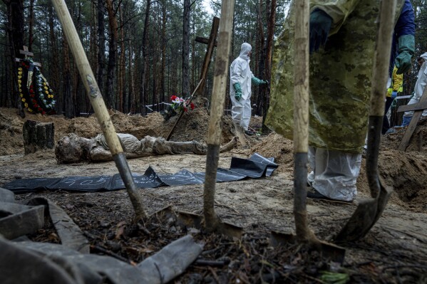 EDS NOTE: GRAPHIC CONTENT - The body of a civilian lies on the ground during an exhumation in the recently retaken area of Izium, Ukraine, Friday, Sept. 23, 2022. (AP Photo/Evgeniy Maloletka)