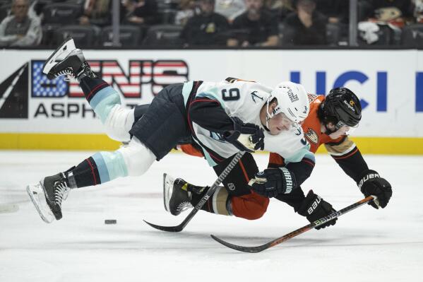 Seattle Kraken center Ryan Donato (9) and Anaheim Ducks defenseman Jamie Drysdale (6) trip while vying for the puck during the first period of an NHL hockey game in Anaheim, Calif., Wednesday, Oct. 12, 2022. (AP Photo/Kyusung Gong)