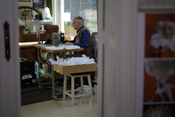 Karl Kersten sits at his sewing machine inside the family costume workshop in Binche, Belgium, Wednesday, Feb. 1, 2023. After a COVID-imposed hiatus, artisans are putting finishing touches on elaborate costumes and floats for the renowned Carnival in the Belgian town of Binche, a tradition that brings together young and old and is a welcome moment of celebration after a rough few years. (AP Photo/Virginia Mayo)