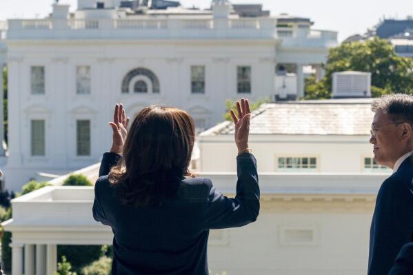 The White House and West Wing are visible as Vice President Kamala Harris, left, meets with South Korean President Moon Jae-in, right, on a balcony of the Eisenhower Executive Office Building in the White House complex in Washington, Friday, May 21, 2021. (AP Photo/Andrew Harnik)