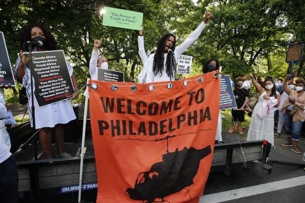 MOVE member Mike Africa speaks during a rally for the 36th anniversary of the MOVE bombing at Osage Avenue and Cobbs Creek Parkway in Philadelphia on Thursday, May 13, 2021. In 1985, the police bombed the group’s headquarters, igniting fuel for a generator and spread to more than 60 rowhomes, killing 11 people including five children.  (Yong Kim/The Philadelphia Inquirer via AP)