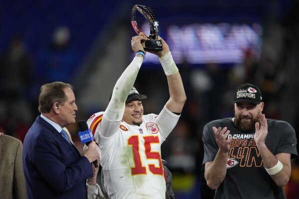 Kansas City Chiefs quarterback Patrick Mahomes (15) holds up the Lamar Hunt Trophy after the AFC Championship NFL football game against the Baltimore Ravens, Sunday, Jan. 28, 2024, in Baltimore. The Chiefs won 17-10. Kansas City Chiefs tight end Travis Kelce stands at right. (AP Photo/Nick Wass)