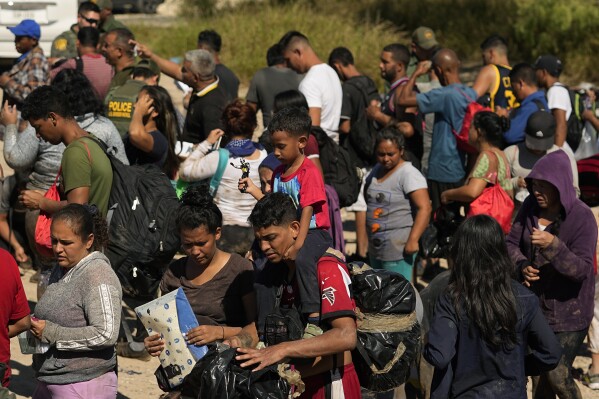 Migrants wait to be processed by the U.S. Customs and Border Patrol after they crossed the Rio Grande and entered the U.S. from Mexico, Thursday, Oct. 19, 2023, in Eagle Pass, Texas. (AP Photo/Eric Gay)