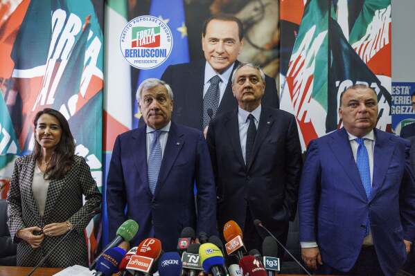 Forza Italia's members, from left, Licia Ronzulli, Antonio Tajani, Paolo Barelli, and Fulvio Martusciello stand in front of a poster of late party founder Silvio Berlusconi Friday, June 16, 2023, during their first party meeting after Berlusconi's death on Monday. Italian Foreign Minister Antonio Tajani said on Friday that in his role of coordinator, he and other party stalwarts loyal to the former premier will keep waging Berlusconi's battles for lower taxes, higher pensions, and reform of the justice system their late leader contended was biased against him. (Roberto Monaldo/LaPresse via AP)