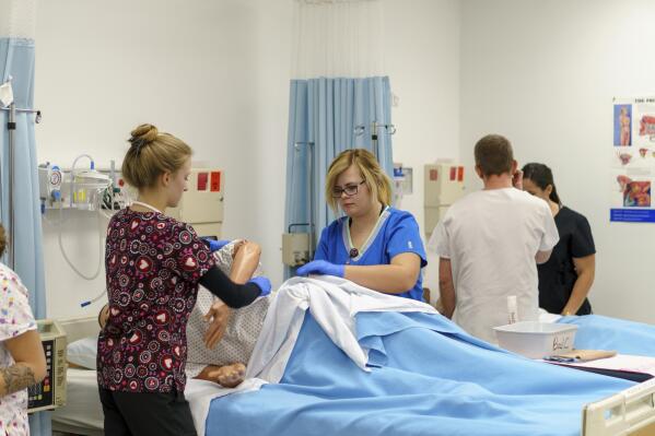 In this Sept. 2019, photo provided by Mohave Community College, Mohave Community College nursing students working in one of the college's high-tech nursing labs, meant to replicate real-life hospitals and medical situations, in Kingman, Ariz. Even before the pandemic, a scarcity of nurses was an ongoing concern in Arizona especially in more rural areas. An Arizona State University nursing program, set to debut at the school's Lake Havasu City campus in fall 2021, aims to put a dent in that shortage. (Mohave Community College via AP)