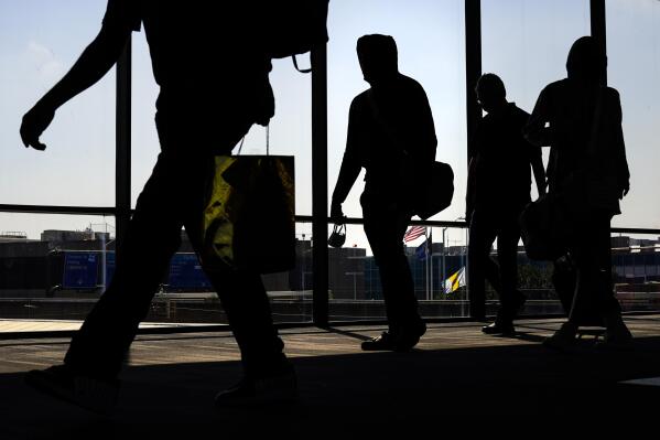 File - Arriving passengers move toward the baggage claim area at Philadelphia International Airport in Philadelphia on Friday, July 1, 2022. Travelers will probably pay more for airline tickets or a hotel room around the holidays than they did over last Thanksgiving or Christmas. (AP Photo/Matt Rourke, File)