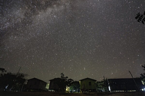 A starry sky shines over the Juma Indigenous community near Canutama, Amazonas state, Brazil, Monday, July 10, 2023. The Juma seemed destined to disappear following the death of the last remaining elderly man, but under his three daughters’ leadership, they changed the patriarchal tradition and now fight to preserve their territory and culture. (AP Photo/Andre Penner)