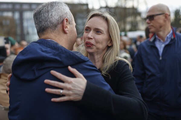 U.S. Ambassador to Lithuania Kara C. McDonald thanks people who come to pay their last respect to the three soldiers found dead on Monday at a training range in Pabrade, near the U.S. Embassy in Vilnius, Lithuania, Tuesday, April 1, 2025. (AP Photo/Mindaugas Kulbis)