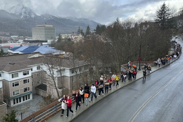 Students and supporters walk from Juneau-Douglas High School: Yadaa.at Kalé to the state Capitol, Thursday, April 4, 2024, in Juneau, Alaska. They marched to the Capitol as part of a student walkout to protest Republican Gov. Mike Dunleavy's veto of an education package last month and the Legislature's failure to override that veto. (AP Photo/Becky Bohrer)