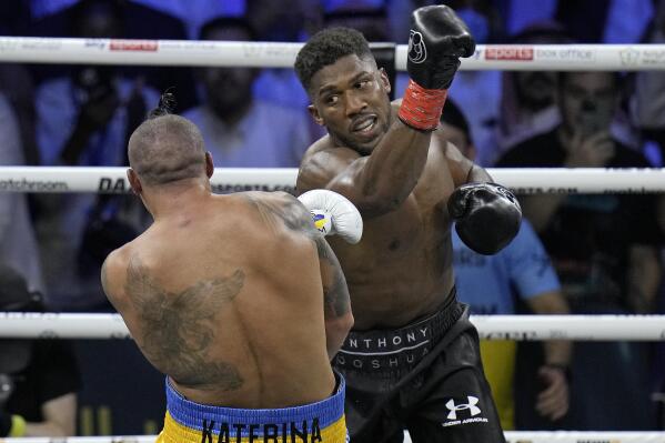 Britain's Anthony Joshua, right, launches a blow at Ukraine's Oleksandr Usyk during their world heavyweight title fight at King Abdullah Sports City in Jeddah, Saudi Arabia, Sunday, Aug. 21, 2022. (AP Photo/Hassan Ammar)