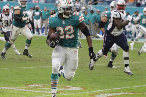 
              Miami Dolphins running back Kenyan Drake (32) runs for a touchdown during the second half of an NFL football game against the New England Patriots, Sunday, Dec. 9, 2018, in Miami Gardens, Fla. The Dolphins defeated the Patriots 34-33. (AP Photo/Lynne Sladky)
            