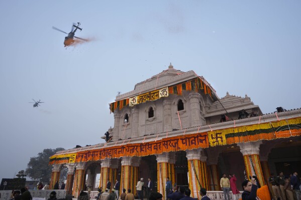 Hubschrauber der indischen Luftwaffe überschütten einen Tempel, der dem Hindu-Gott Lord Ram gewidmet ist, am Tag vor der feierlichen Eröffnung des Tempels in Ayodhya, Indien, Sonntag, 21. Januar 2024, mit Blütenblättern. (AP Photo/Rajesh Kumar Singh)