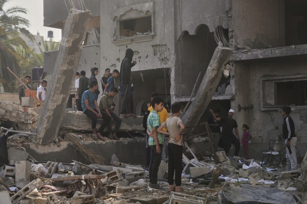 Palestinos revisan una casa destruida por ataques israelíes en Deir al-Balah, el miércoles 21 de mayo de 2025. (AP Foto/Abdel Kareem Hana)