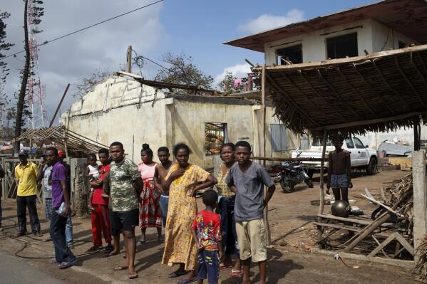 FILE — People outside ruined homes in Mananjary, Madagascar, Feb. 10, 2022. The island of Madagascar off the east coast of Africa is bracing for yet another cyclone having already been hit by three major tropical storms in the last month. Cyclone Emnati is expected to make landfall on the eastern coast of Madagascar late Tuesday Feb. 22, 2022, amid fears it will be a stronger storm than the three that have left nearly 200 people dead this cyclone season. (AP Photo/Viviane Rakotoarivony, File)