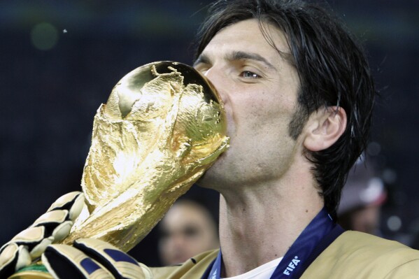 FILE - Italy's goalkeeper Gianluigi Buffon kisses the World Cup trophy after defeating France 5-3 in a penalty shootout in the final of the soccer World Cup between Italy and France in the Olympic Stadium in Berlin, Sunday, July 9, 2006. At age 45 and after a career that included a World Cup title with Italy, a long list of trophies with Juventus and many years when he was considered among the best goalkeepers in soccer, Gianluigi Buffon announced his retirement on Wednesday, Aug. 2, 2023. (AP Photo/Thomas Kienzle)