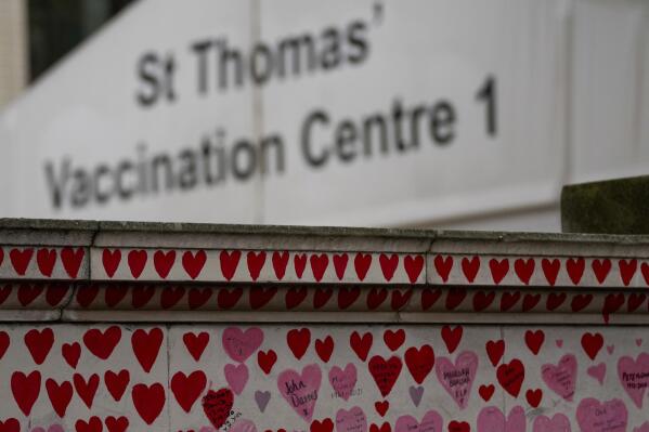 The vaccination center of St Thomas' Hospital sits behind the National Covid Memorial Wall in London, Tuesday Nov. 9, 2021. The British government is due to decide about mandatory vaccination for NHS staff.(AP Photo/Frank Augstein)