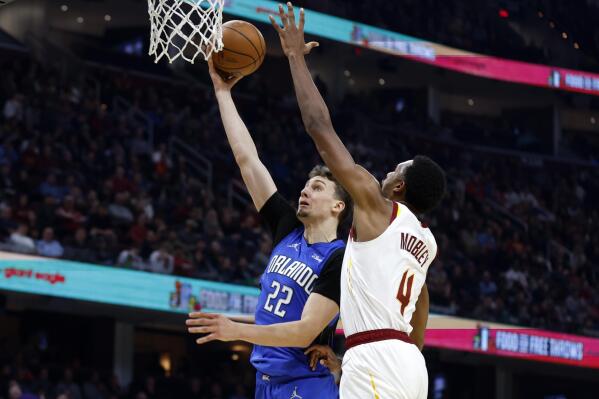 Orlando Magic's Franz Wagner (22) shoots against Cleveland Cavaliers' Evan Mobley (4) during the first half of an NBA basketball game, Monday, March 28, 2022, in Cleveland. (AP Photo/Ron Schwane)