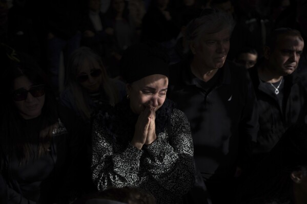 Family and friends mourn the grave of Israeli soldier Lt. Yaakov Elyan during his funeral at the Kiryat Shal cemetery in Tel Aviv, Israel, where Hamas is fighting Palestinian militants in a war sparked by an attack on Israel on October 7.  (AP Photo/Odd Polity)