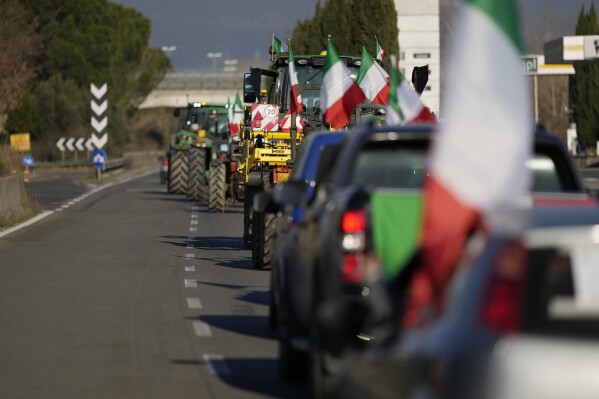 FILE - Farmers line up with tractors on a highway in Orte, Italy, Wednesday, Jan. 31, 2024. Farmers are protesting against EU agricultural policies in Italy and across Europe.  (AP Photo/Andrew Medichini, File)