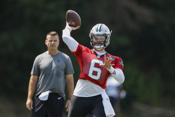 Carolina Panthers quarterback Baker Mayfield throws a pass as quarterbacks coach Sean Ryan looks on at the NFL football team's training camp at Wofford College in Spartanburg, S.C., Wednesday, July 27, 2022. (AP Photo/Nell Redmond)