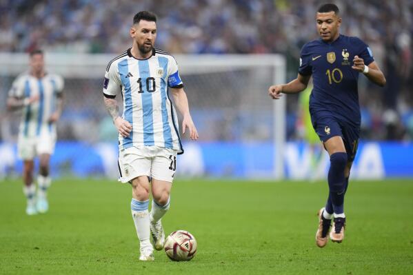 Argentina's Lionel Messi goes for the ball next to France's Kylian Mbappe during the World Cup final soccer match between Argentina and France at the Lusail Stadium in Lusail, Qatar, Sunday, Dec.18, 2022. (AP Photo/Manu Fernandez)