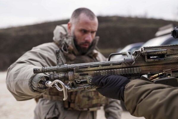 Andrii Rubliuk, a senior sergeant with a Ukrainian intelligence unit who lost both arms and a leg in combat, takes part in military training near Kyiv, Ukraine, on Feb. 14, 2025. (AP Photo/Evgeniy Maloletka)