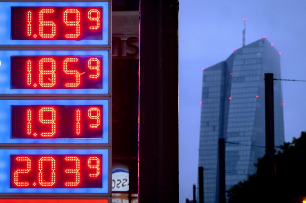 FILE - Gas prices are displayed at a gas station next to the headquarters of the European Central Bank, rear, in Frankfurt, Germany, on July 28, 2023. Germany's economy shrank 0.3% last year as Europe's former powerhouse struggled with more expensive energy, higher interest rates, lack of skilled labor and a home-grown budget crisis. (AP Photo/Michael Probst, File)