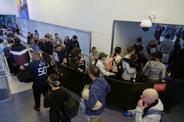 Reizigers wachten op donderdag 23 mei 2024 bij een TSA-controlepunt op de internationale luchthaven van Los Angeles in Los Angeles.  Er wordt verwacht dat een recordaantal Amerikanen zal reizen tijdens het Memorial Day-weekend van 2024 (AP Photo/Ryan Sun)