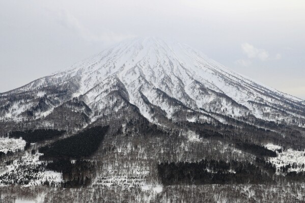 This aerial photo shows Mt. Yotei where an avalanche hit a group of backcountry skiers, in Kutchan, Hokkaido, on March 11, 2024. Two backcountry skiers have died in a mountain avalanche on Japan’s northernmost main island of Hokkaido, according to news reports. (Kyodo News via AP)