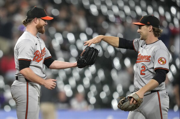 Baltimore Orioles shortstop Gunnar Henderson, right, gives relief pitcher Craig Kimbrel the game ball after the Orioles defeated the Chicago White Sox on Thursday, May 23, 2024, in Chicago. Henderson caught a popup by Andrew Benintendi, and caught Andrew Vaughn off second for an unassisted double play to end the game. (AP Photo/Charles Rex Arbogast)