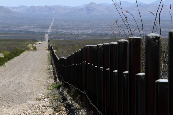 FILE - A U.S. Customs and Border Patrol truck, in the distance, patrols the U.S. border with Mexico, March 18, 2016, in Douglas, Ariz. The sheriff of Cochise County, Arizona's easternmost border county, asked state and federal officials for help Thursday, Sept. 14, 2023, with the sudden daily arrival of more than 100 migrants seeking asylum in the U.S., including families with small children. (AP Photo/Ricardo Arduengo, File)