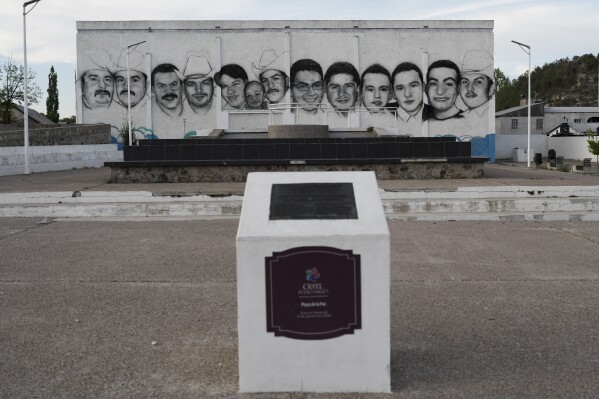The faces of 13 residents who were gunned down in the town square of Creel, Mexico, cover a wall as a memorial, Monday, May 13, 2024. Armed men opened fire against the locals hanging out in the public square in 2008, and Jesuit Priest Javier Avila arrived at the massacre site.“There were bodies everywhere,” Ávila said. “But no signs of the police.” (AP Photo/Eduardo Verdugo)
