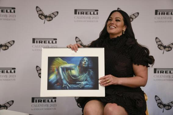 Model Ashley Graham holds her picture on the Pirelli calendar as she discusses her appearance in the 2023 Pirelli calendar during a press preview at the 15th Century Bicocca degli Arcimboldi Villa at Pirelli's headquarters in Milan, Italy, Tuesday, Nov. 15, 2022. The 2023 calendar titled "Love Letters to the Muse" was shot by Australia photographer Emma Summerton and features models representing their personal passions. (AP Photo/Luca Bruno)