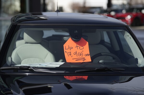 A sign noting a discount is displayed in an unsold 2024 Cooper SE electric hardtop at a Mini dealership on Thursday, Nov. 30, 2023, in Loveland, Colo. EV inventory is building on dealer lots, and many EV models are taking longer to sell than gas counterparts. (AP Photo/David Zalubowski)