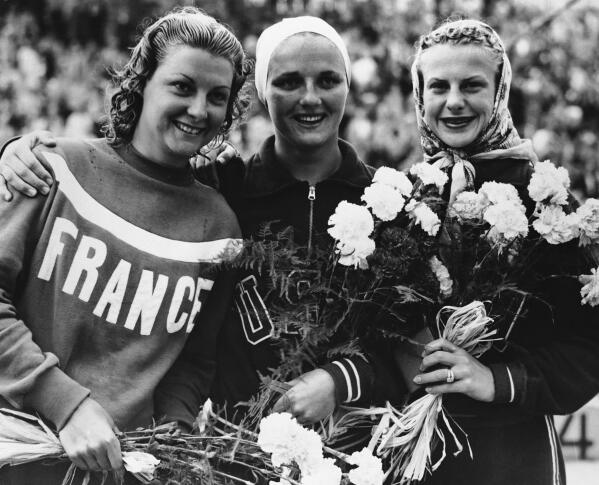 File - From left to right, Madeleine Moreau, of France (silver medallist, 139.34 points); Patricia McCormick, of the United States (gold, 147.30 points); and United States' Zoe Jensen (bronze, 127.57 points), spose after the women's 3-meter springboard diving event at the Summer Olympics Games in Helsinki, Finland, on July 30, 1952. McCormick died Tuesday, March 7, 2023, in Santa Ana, Calif., at age 92, according to her son, Tim McCormick. (AP Photo/Pool, File)