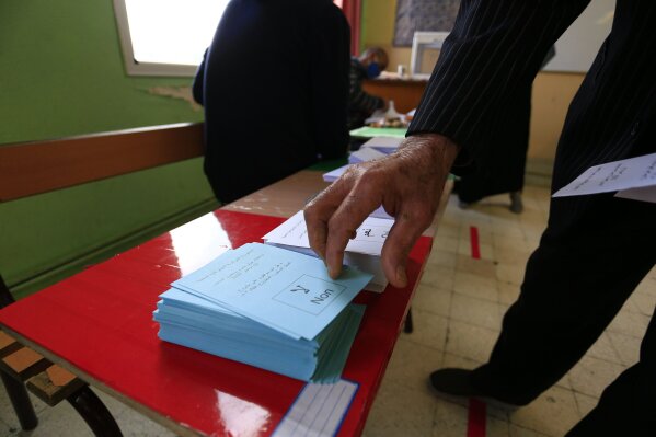 A man prepares to vote at a polling station during a vote for a revised constitution, in Algiers, Sunday, Nov. 1, 2020. Algerians are voting on whether to approve a revised constitution that imposes term limits and aims at answering demands from pro-democracy protesters who pushed out the president last year. (AP Photo/Toufik Doudou)