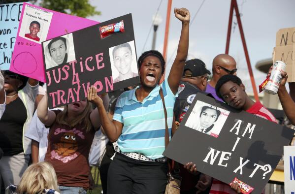 In this March 22, 2012 file photo, protestors, Lakesha Hall, of Sanford, center, and her son, Calvin Simms, right, participate in a rally for Trayvon Martin, the black teenager who was fatally shot by George Zimmerman, a neighborhood watch captain in Sanford, Fla. The killing of Trayvon Martin at the hands of a stranger still reverberates 10 years later -- in protest, in partisanship, in racial reckoning and reactionary response, in social justice and social media. (AP Photo/Julie Fletcher, File)