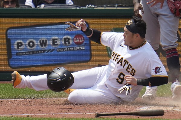 Pittsburgh Pirates' Ji Man Choi scores the second of two runs on a single by Jared Triolo off Cleveland Guardians relief pitcher Enyel De Los Santos during the seventh inning of a baseball game in Pittsburgh, Wednesday, July 19, 2023. The Pirates won 7-5. (AP Photo/Gene J. Puskar)