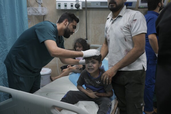 A Palestinian boy, wounded in Israeli bombardment on Gaza Strip, cries in a hospital in Deir al-Balah, south of the Gaza Strip, Saturday, Oct. 21, 2023. (AP Photo/Hatem Moussa)
