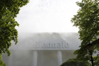 FILE - A building with writing Biennale is surrounded by a smoke effect in view of the 58th Biennale of Arts exhibition in Venice, Italy, on May 7, 2019. Thousands of artists, curators and critics have signed an open letter calling on the Venice Biennale to exclude the Israeli national pavilion from this year’s contemporary art fair due to the war in Gaza, but Italy’s culture minister firmly backed Israel’s participation. The on-line letter was signed by more than 17,000 people through Wednesday, Feb. 28, 2024 which included current and past Biennale participants as well as Turner Prize winners. (AP Photo/Antonio Calanni, File)