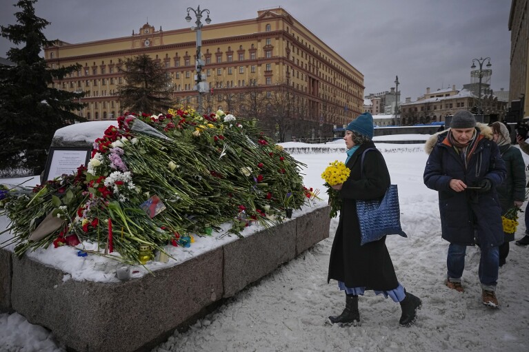 FILE - People lay flowers to honor Alexei Navalny, who died in prison on Feb. 16, 2024, at a monument to victims of Soviet repression in Moscow, Russia, on Saturday, Feb. 17, 2024. Over the last decade, Vladimir Putin's Russia evolved from a country that tolerates at least some dissent to one that ruthlessly suppresses it. Arrests, trials and long prison terms — once rare — are commonplace.(AP Photo, File)