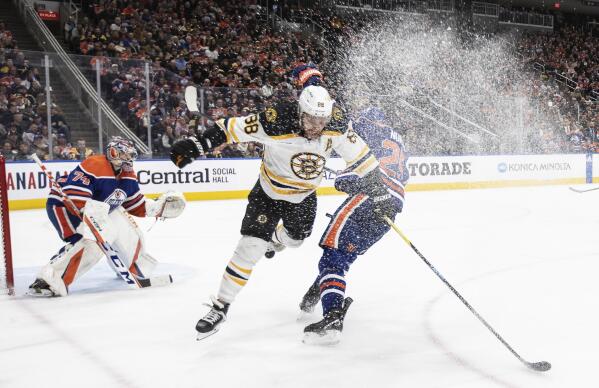Boston Bruins' David Pastrnak (88) is checked by Edmonton Oilers' Darnell Nurse (25) as Oilers goalie Stuart Skinner (74) looks for a shot during third-period NHL hockey game action in Edmonton, Alberta, Monday, Feb. 27, 2023. (Jason Franson/The Canadian Press via AP)