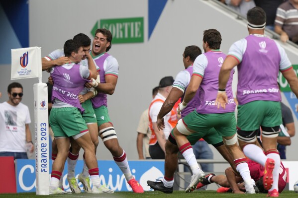 Portugal's Raffaele Storti celebrates with teammates after scoring a try during the Rugby World Cup Pool C match between Georgia and Portugal at the Stadium de Toulouse in Toulouse, France, Saturday, Sept. 23, 2023. (AP Photo/Lewis Joly)