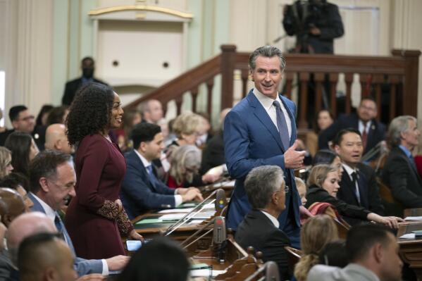 California Gov. Gavin Newsom walks through the assembly chamber with California Controller Malia Cohen during the opening session of the California Legislature in Sacramento, Calif., Monday, Dec. 5, 2022. The legislature returned to work on Monday to swear in new members and elect leaders for the upcoming session. (AP Photo/José Luis Villegas, Pool)
